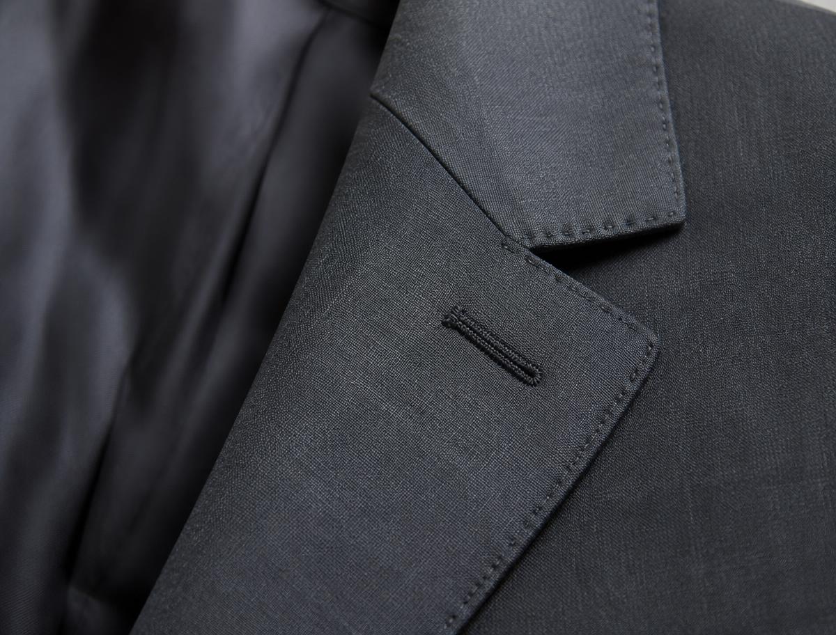Close-up of a hand-padded notch lapel on a navy suit jacket