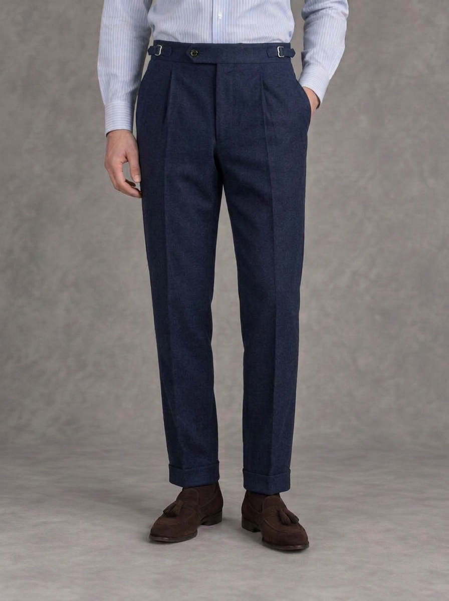 Navy single-pleat flannel trousers with side adjusters and turn-ups, worn with a striped blue shirt and brown suede tassel loafers