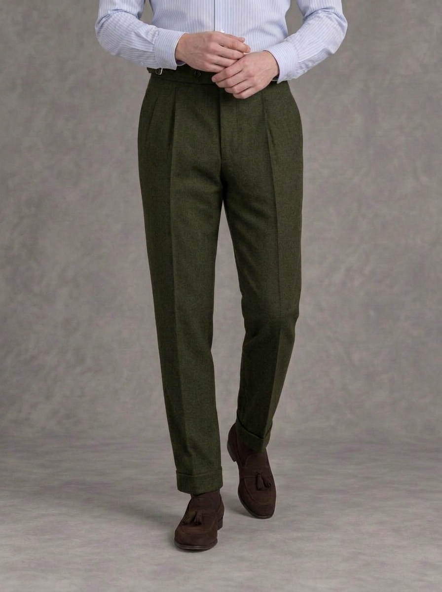 Dark olive single-pleat flannel trousers with side adjusters and turn-ups, worn with a striped blue shirt and brown suede tassel loafers
